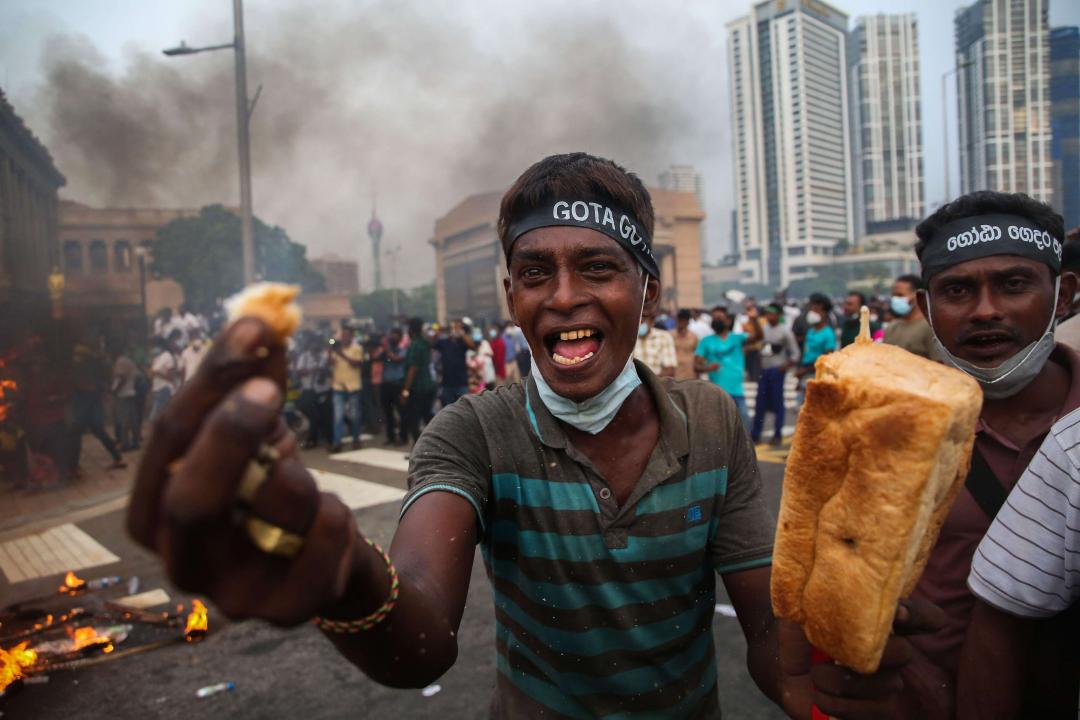 A protestor in Colombo on 15 March, wearing a "Gotagohome" headband, displays a loaf of bread to highlight rising food prices | Pradeep Dambarage/ZUMA Press Wire
