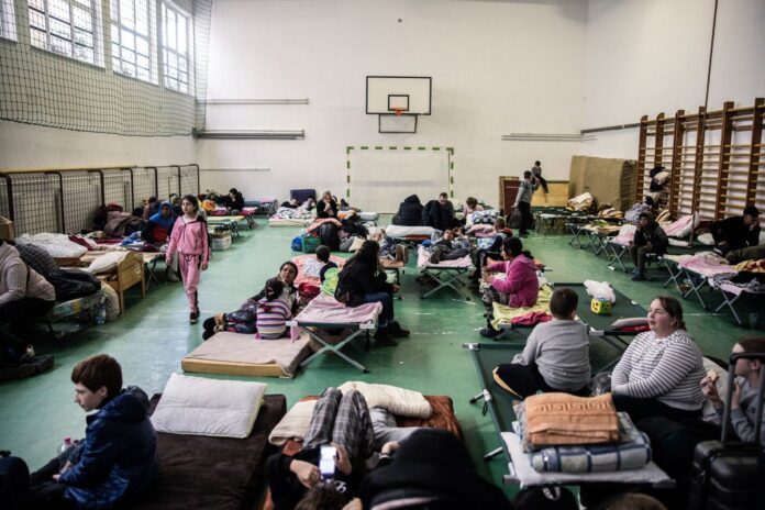 Displaced Ukrainians at a temporary shelter inside a gymnasium in Tiszabecs, Hungary, on Feb. 28. Photographer: Akos Stiller