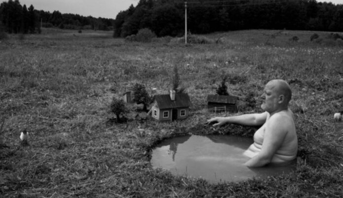 Hombre bañandose en un charco, foto surrealista